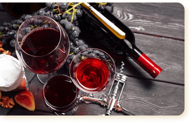 Bottle and glasses of red wine on a dark wooden table